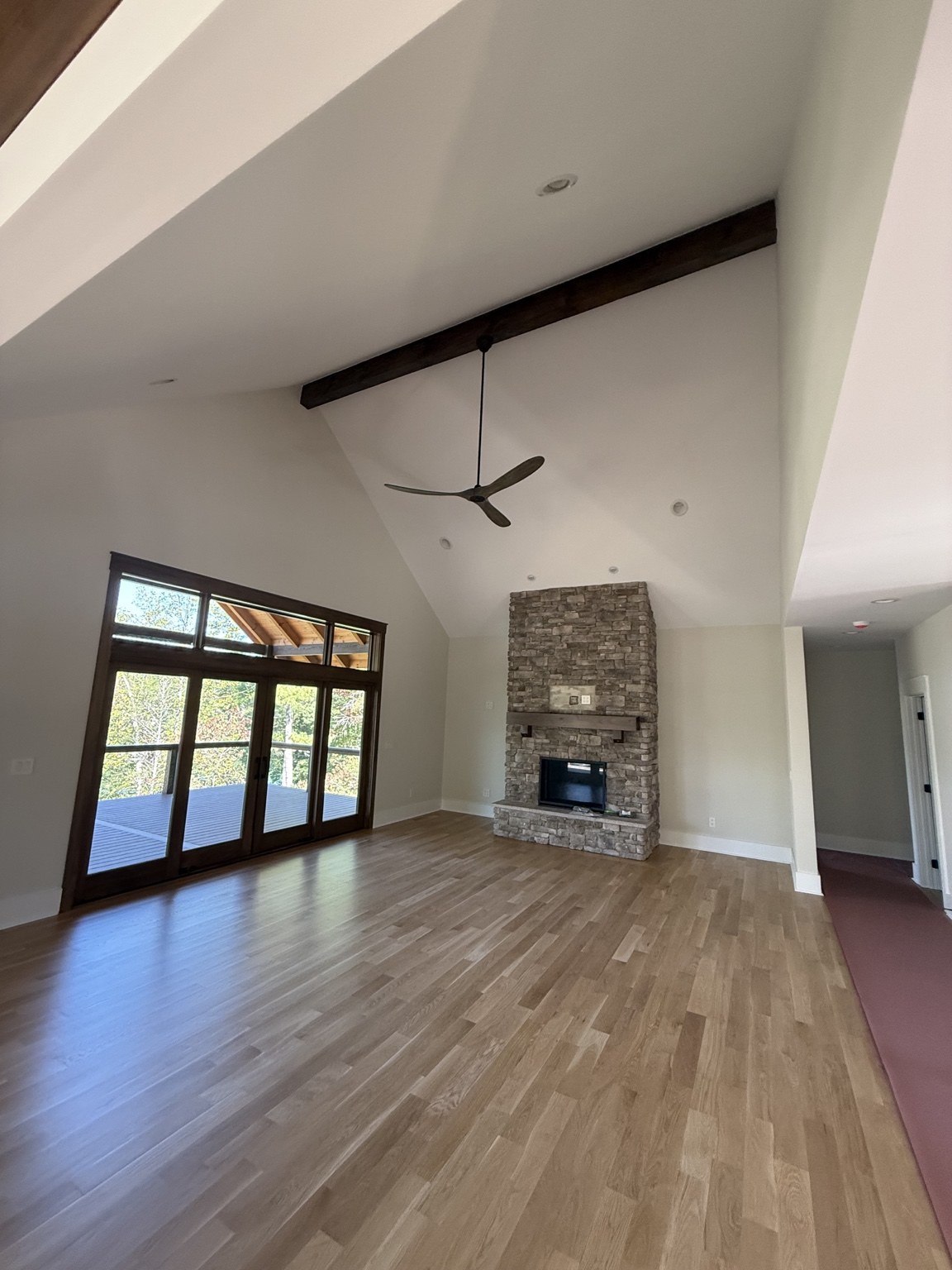 Recessed lighting and ceiling fan in a great room with exposed beams