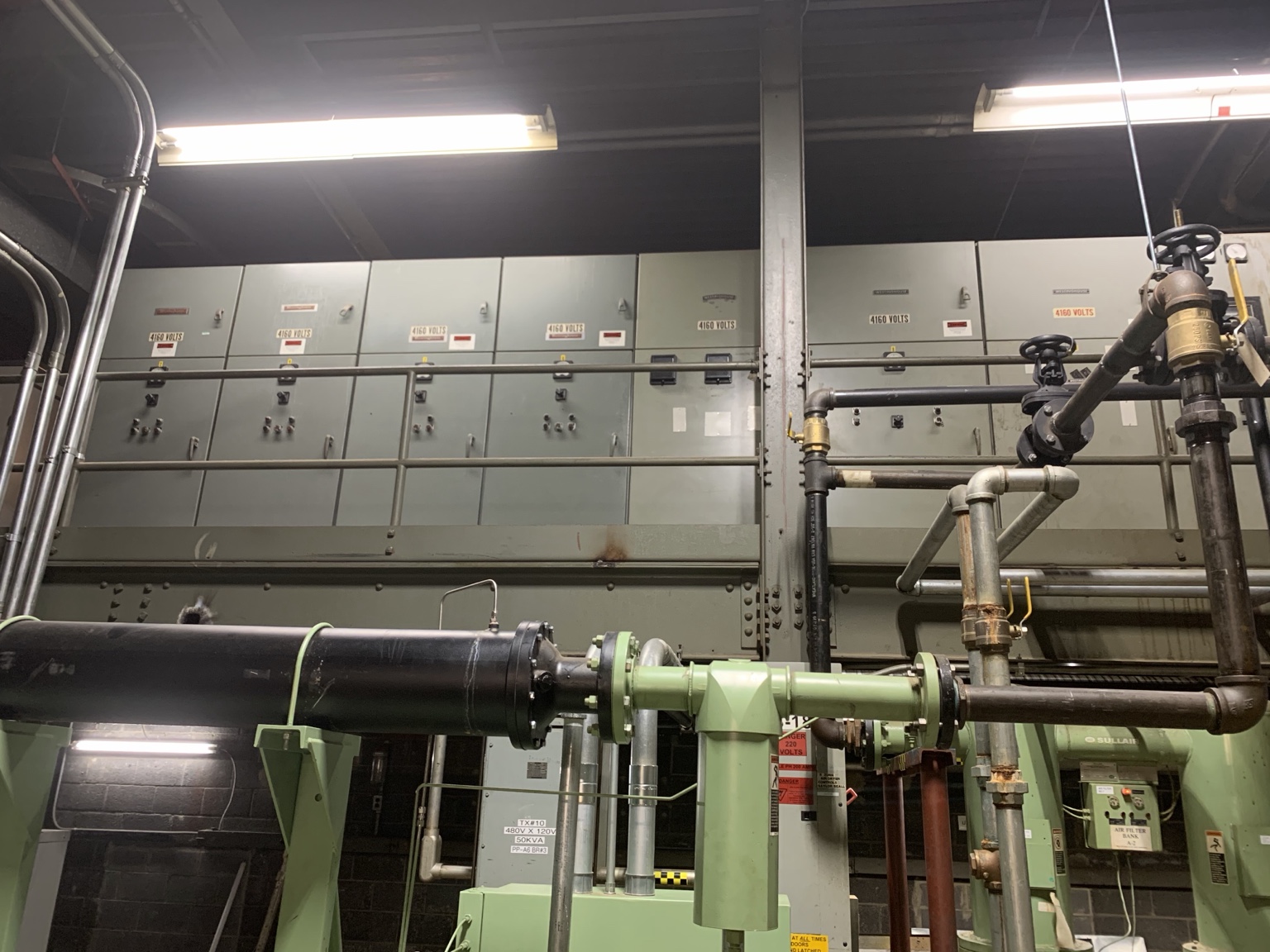 Electrical distribution and control cabinets above industrial machinery